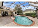 Inviting in-ground pool with screened enclosure and brick patio, perfect for outdoor relaxation and entertaining at 8308 Mobile Cir, Weeki Wachee, FL 34613