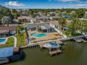 Stunning waterfront property featuring a private pool, patio, boat dock, and beautifully landscaped backyard at 8722 Thornwood Ln, Tampa, FL 33615