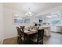 Dining room with chandelier and large window with adjacent modern, white kitchen at 1010 Oakhill St, Seffner, FL 33584