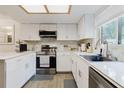 Modern kitchen with white cabinetry, stainless steel appliances, and marble countertops at 1010 Oakhill St, Seffner, FL 33584