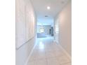 Bright hallway featuring tile flooring, modern wall art, and inviting living space at 10210 White Linen Ave, Riverview, FL 33578