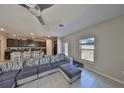 Open concept living area featuring a large sectional sofa, tile floors, and a modern ceiling fan at 10210 White Linen Ave, Riverview, FL 33578