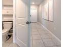 Hallway view including toilet room with tiled floors and white fixtures at 10210 White Linen Ave, Riverview, FL 33578