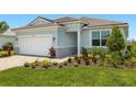 Charming single-story home featuring a paver driveway, well-manicured lawn, and a two-car garage at 11737 Myakka Blue Dr, Venice, FL 34293