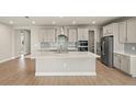 Modern kitchen with a large center island, stainless steel appliances, and stylish gray cabinets at 11737 Myakka Blue Dr, Venice, FL 34293