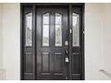 Dark wooden front door with glass panels and silver hardware at 12099 Luxembourg Ct, Spring Hill, FL 34609