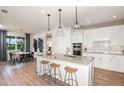 Well-lit kitchen and dining area with hardwood floors, quartz countertops, pendant lighting, and stainless steel appliances at 12626 Glenn Creek Dr, Riverview, FL 33569