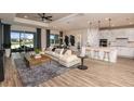 Bright living room featuring hardwood floors, neutral paint, and view of a lake with outdoor dining area at 12626 Glenn Creek Dr, Riverview, FL 33569