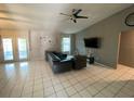 Open living room with vaulted ceiling, ceiling fan and tile floors at 12912 Leadwood Dr, Riverview, FL 33579