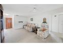 Bright living room with neutral carpet, ceiling fan, and comfortable seating at 13563 Cordova Dr, Largo, FL 33774