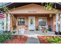 Inviting front porch area with decorative chairs, plants, and a charming welcome mat at 14000 104Th Ave, Largo, FL 33774