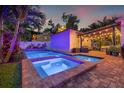 Backyard pool and spa with brick pavers, illuminated by string lights and colorful lighting for evening enjoyment at 1436 30Th N Ave, St Petersburg, FL 33704
