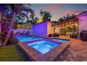 Backyard pool and hot tub with brick surround and lights with pergola at night at 1436 30Th N Ave, St Petersburg, FL 33704