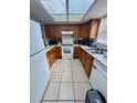Functional kitchen featuring light countertops, white appliances, and dark wood cabinetry at 144 Douglas W Rd # F, Oldsmar, FL 34677
