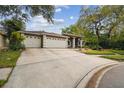 Exterior view of a home with a long driveway and a 2-car garage showcasing landscaping at 160 Sage Cir, Crystal Beach, FL 34681