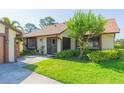 Quaint single-story house with lush greenery, and a cozy screened front entry at 2211 Bay Berry Ln, Clearwater, FL 33763