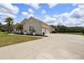 View of home's exterior showing a long driveway leading to a three-car garage at 2214 132Nd E Pl, Parrish, FL 34219