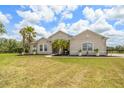 Charming single-story home featuring a landscaped front yard with palm trees and attractive architectural details at 2214 132Nd E Pl, Parrish, FL 34219