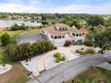 Elegant white home with a tile roof, a screened pool, and manicured landscaping at 2333 Camp Indianhead Rd, Land O Lakes, FL 34639