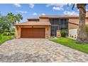 Exterior view of home showcasing the brick driveway and attached garage at 2421 Lake Point Ln, Clearwater, FL 33762