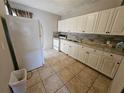 Functional kitchen featuring tiled floors and white cabinets at 2510 Queen S St, St Petersburg, FL 33712