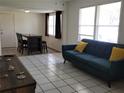 Open concept living room with tile floors, dining area, and large windows at 2701 47Th N Ave, St Petersburg, FL 33714