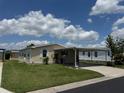 Well-maintained single-story home with covered parking, complemented by neat landscaping and a sunny, partly cloudy sky at 3041 Short Leaf St, Wesley Chapel, FL 33543