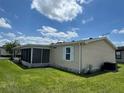 Exterior view showcasing a screened lanai addition and a well-maintained yard, under a beautiful blue sky at 3041 Short Leaf St, Wesley Chapel, FL 33543