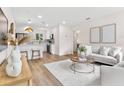 Bright and open living room featuring modern decor and hardwood flooring with kitchen view at 411 37Th S St, St Petersburg, FL 33711