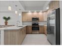 Modern kitchen featuring stainless steel appliances, light wood cabinets, and quartz countertops at 415 Island Way # 303, Clearwater Beach, FL 33767