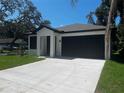 Lovely home with a spacious driveway, attached garage, and neatly kept lawn, all under a clear blue sky at 4241 E Palifox St, Tampa, FL 33610