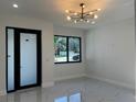 Bright, airy living room with large windows, sleek tile floors, and a modern light fixture at 4241 E Palifox St, Tampa, FL 33610