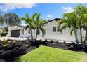 Landscaped front yard with palm trees in front of a painted brick home at 4618 Bayshore Ne Blvd, St Petersburg, FL 33703
