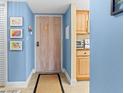 Cozy condo entryway featuring light blue walls, beach themed art, and a wood-look door at 4900 Brittany S Dr # 209, St Petersburg, FL 33715