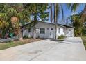 Single-story home with a freshly painted white exterior and a concrete driveway at 5013 W Mccoy St, Tampa, FL 33616