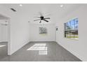 Bright living room with gray floors, modern ceiling fan, and natural light at 5013 W Mccoy St, Tampa, FL 33616