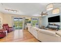 Bright living room featuring hardwood floors, large windows, and comfortable seating at 5435 Sweetwater Terrace Cir, Tampa, FL 33634