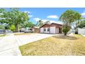 Charming single-story home featuring a concrete driveway and mature landscaping at 6915 N Hubert Ave, Tampa, FL 33614