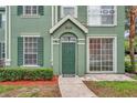 Green townhouse with decorative shutters and manicured landscaping at 9602 Lake Chase Island Way # 9602, Tampa, FL 33626