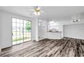 Bright living room boasts wood floors and sliding glass doors to patio at 9602 Lake Chase Island Way # 9602, Tampa, FL 33626
