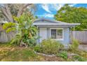 Charming home with a blue exterior, nice lawn, plants, and lovely landscaping at 10208 N 23Rd St, Tampa, FL 33612