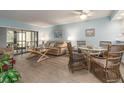 Bright living room featuring a dining area, light blue walls, and sliding doors to the lanai at 105 Woodlake Wynde, Oldsmar, FL 34677