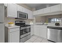 Well-lit kitchen featuring stainless steel appliances, white cabinets, and a convenient pass-through to the dining area at 1118 Kennewick Ct, Wesley Chapel, FL 33543