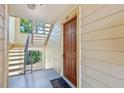 Condo entrance featuring a wood door, light-colored siding, and stairway access at 11901 4Th N St # 8207, St Petersburg, FL 33716