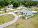 Expansive property featuring a gray-roofed home with screened-in porch, detached garage, and mature palm trees at 12501 Palomino Ct, Tampa, FL 33626