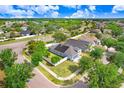 Aerial view of a home with solar panels, surrounded by green landscapes and other residential properties at 13404 Fladgate Mark Dr, Riverview, FL 33579
