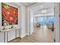 Lovely condo foyer with wood floors, stylish furniture and artwork and views into the dining area and out to the water beyond at 140 Riviera Dunes Way # 1203, Palmetto, FL 34221