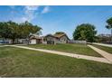 Single-story home with manicured lawn, paved driveway, and inviting curb appeal at 1402 Oleander Dr, Tarpon Springs, FL 34689
