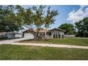 Single-story home with manicured lawn, paved driveway, and inviting curb appeal at 1402 Oleander Dr, Tarpon Springs, FL 34689