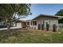 Charming single-story home with stone facade, well-manicured lawn, and garage at 1402 Oleander Dr, Tarpon Springs, FL 34689